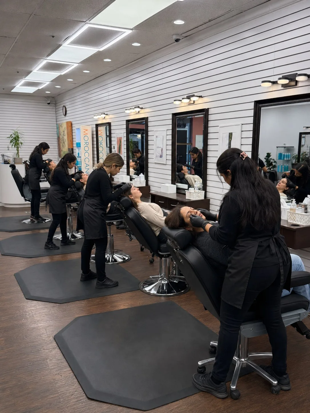 Estheticians threading clients along the treatment row at PT Salon Pleasanton